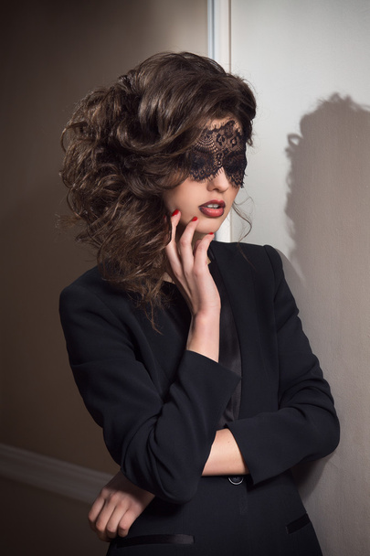 gyönyörű nő barna luxus estélyi ruha és maszkot visel - Fotó, kép