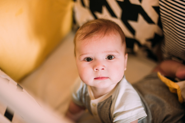 ベビーベッドを自宅で陽気なかわいい赤ちゃんのクローズ アップの肖像画 - 写真・画像