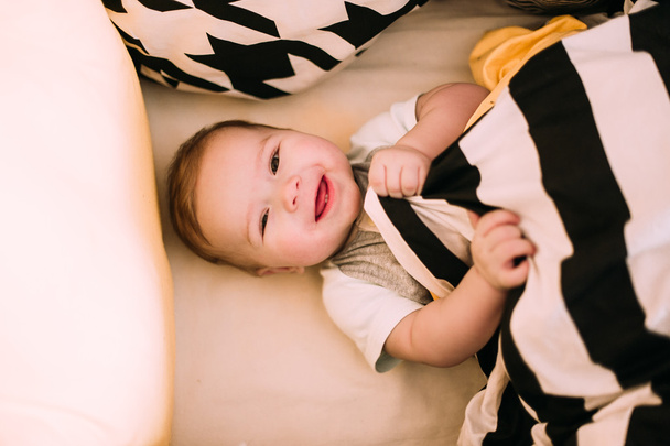 Крупный план портрета веселого милого малыша в кроватке дома
 - Фото, изображение