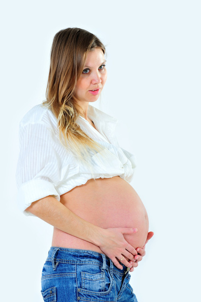 pregnant girl is posing with naked belly on white background - Photo, Image