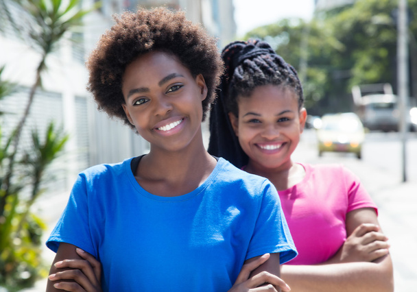 Twee moderne Afrikaanse Amerikaanse vriendinnen in de stad - Foto, afbeelding