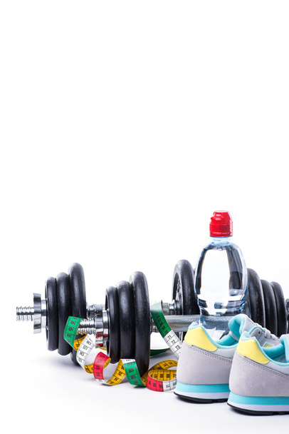 Dumbbells with measuring tape, sneakers and bottle of water on white - Fotoğraf, Görsel