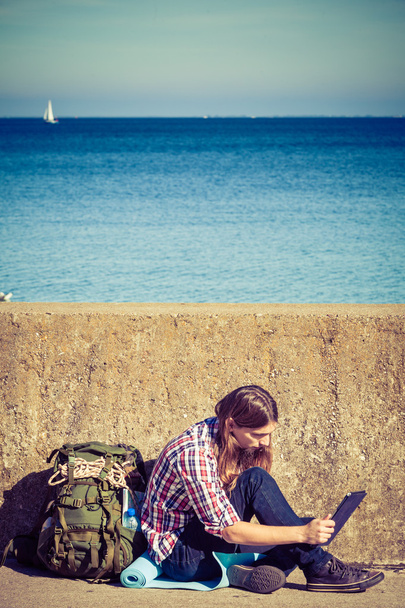 Man tourist backpacker sitting with tablet outdoor - Φωτογραφία, εικόνα