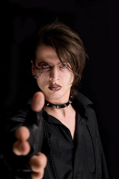 Gothic boy with artistic make-up pointin - 写真・画像
