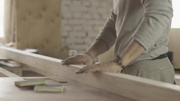 Profesjonalnego stolarza sprawdzanie powierzchnię płyty drewniane po leczeniu. - Materiał filmowy, wideo