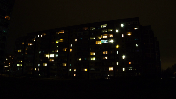Několikapatrová budova s proměnlivým oknem osvětlení v noci. Časová prodleva - Záběry, video