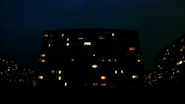 Několikapatrová budova s proměnlivým oknem osvětlení v noci. Časová prodleva - Záběry, video