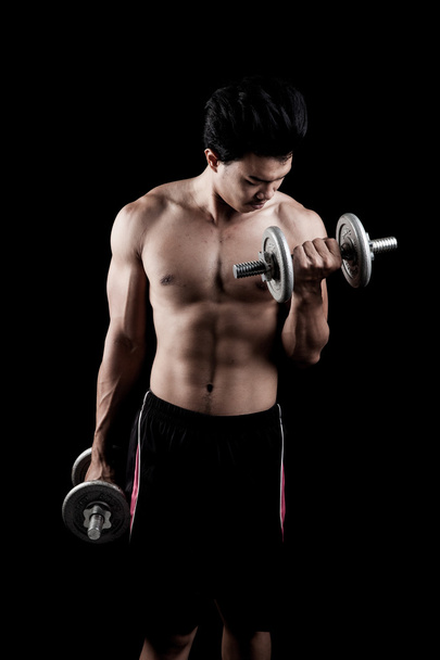 Muscular Asian man with dumbbell - Photo, image
