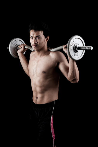 Muscular Asian man  with barbell - Фото, изображение