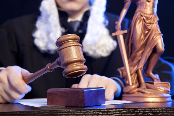 Male judge in a courtroom striking the gavel - Фото, зображення