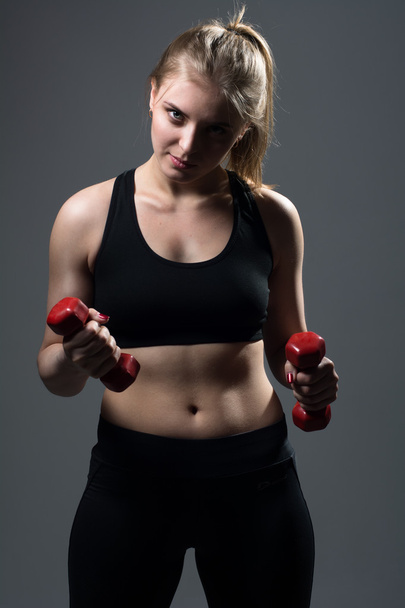 Athletic young woman doing a fitness workout with dumbbells - Photo, Image