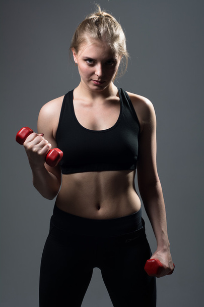 Athletic young woman doing a fitness workout with dumbbells - Fotoğraf, Görsel