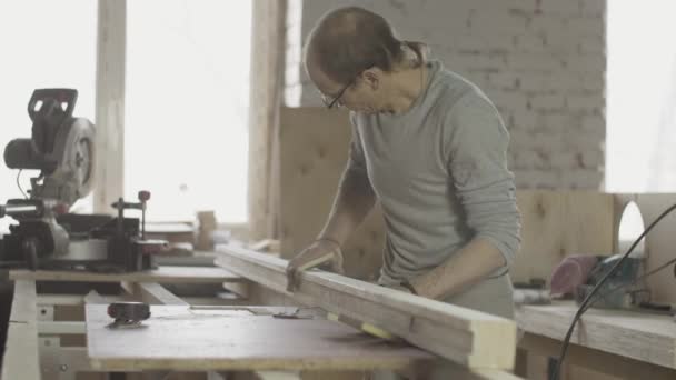 professionelle Holzbearbeiter polieren lange Holzbretter mit einem speziellen Schwamm. Möbel. - Filmmaterial, Video