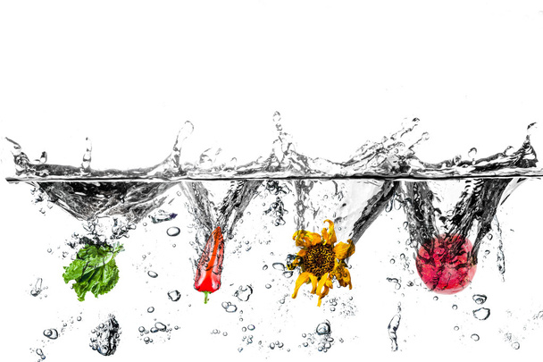 Вода брызгает салатом, перцем, подсолнухом и гранатом
 - Фото, изображение