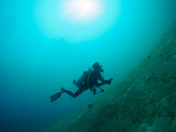 Mannelijke duiker zwemmen onder water - Foto, afbeelding