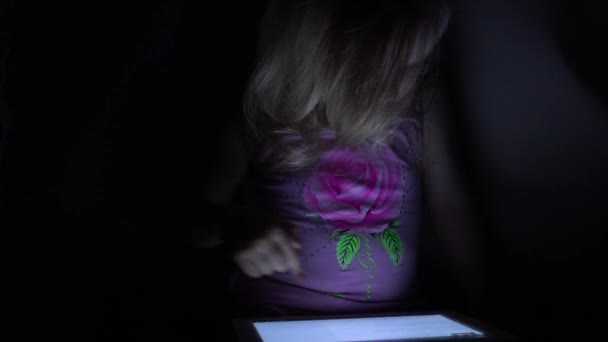 Cute Little Girl Works on Tablet Computer in Dark Room. 4K UltraHD, UHD - Imágenes, Vídeo