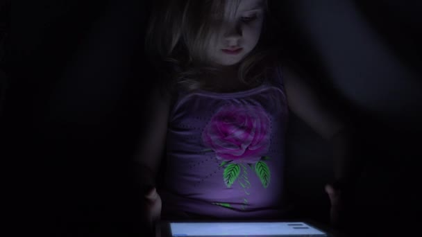 Cute Little Girl Works on Tablet Computer in Dark Room. 4K UltraHD, UHD - Felvétel, videó