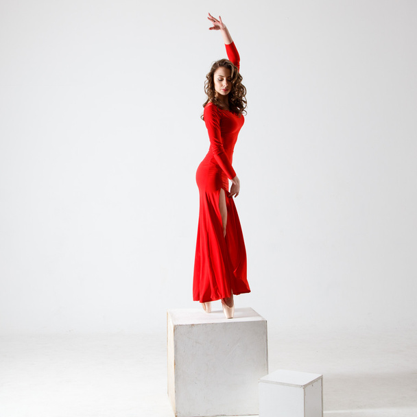 Tanzende Dame im roten Kleid. zeitgenössischer moderner Tanz auf weißem Hintergrund. Fitness, Stretching-Modell - Foto, Bild
