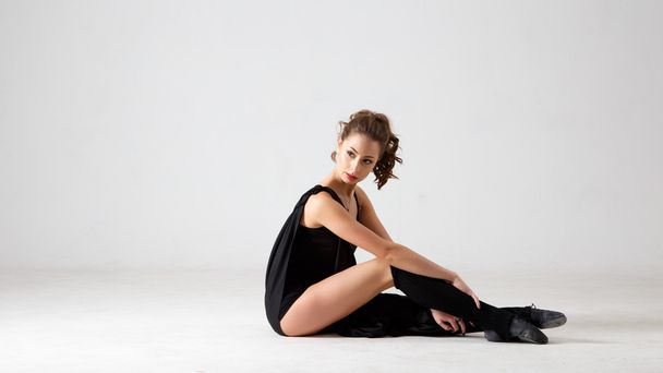 Dancing lady in a black clothes. Contemporary modern dance on a white background isolated. Fitness, stretching model - Фото, зображення