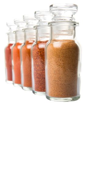 Assortment of chilly powder, paprika powder and cayenne powder in glass vial over white background - Photo, Image