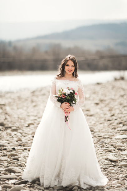 Girl, model, bride on a background of the river and mountains. Beauty portrait - Foto, imagen