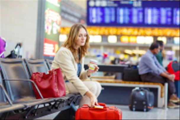 женщина в международном аэропорту ждет рейса в терминале
 - Фото, изображение