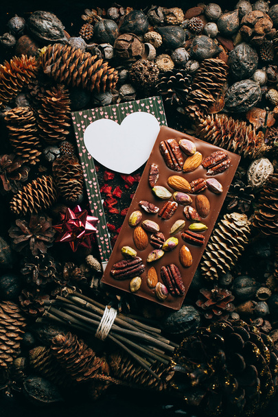 Composizione di cioccolato con noci su sfondo coni - Foto, immagini