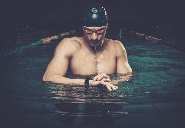 Κολυμβητής με το όργανο ελέγχου ποσοστού καρδιών στην πισίνα - Φωτογραφία, εικόνα