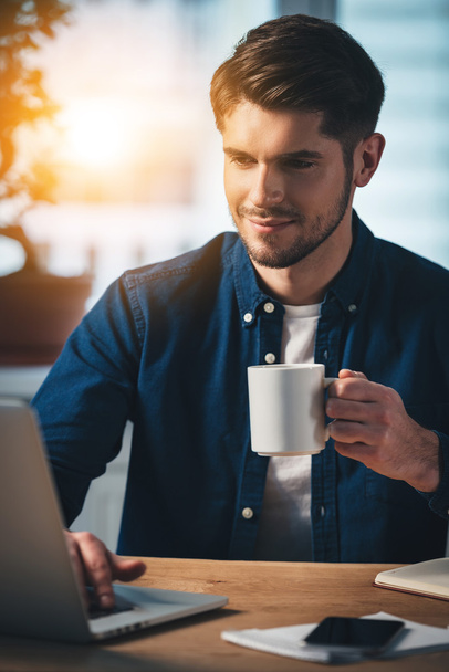 uomo con tazza di caffè con computer portatile
 - Foto, immagini