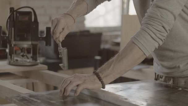 Holzarbeiter befestigen Metallbalken auf Holzbrettern. Prozess der Möbelherstellung. - Filmmaterial, Video