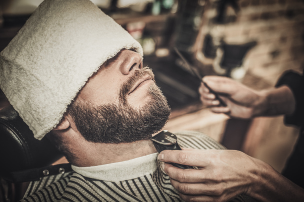Πελάτη κατά τη διάρκεια του γένια και μουστάκι περιποίηση  - Φωτογραφία, εικόνα