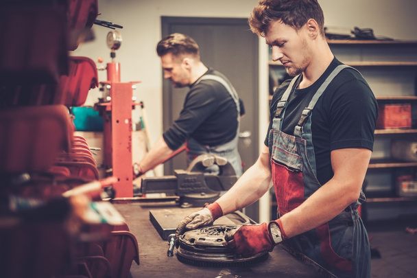 professionelle Kfz-Mechaniker arbeiten am Arbeitstisch im Auto-Reparaturservice. - Foto, Bild
