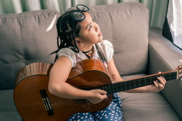 Щаслива усміхнена дівчина, вчиться грати на акустичній гітарі
 - Фото, зображення
