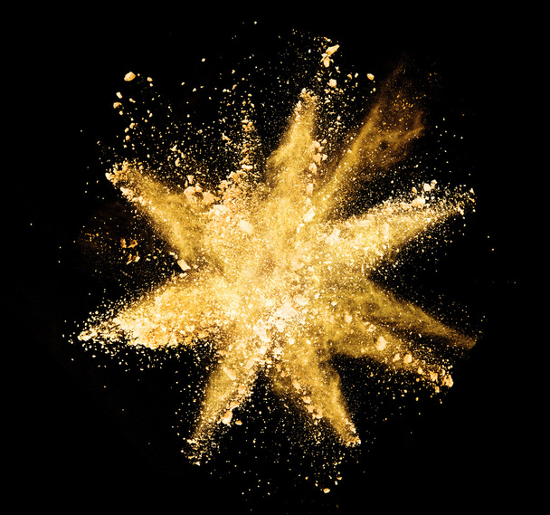 Explosion of yellow powder on black background - Foto, afbeelding