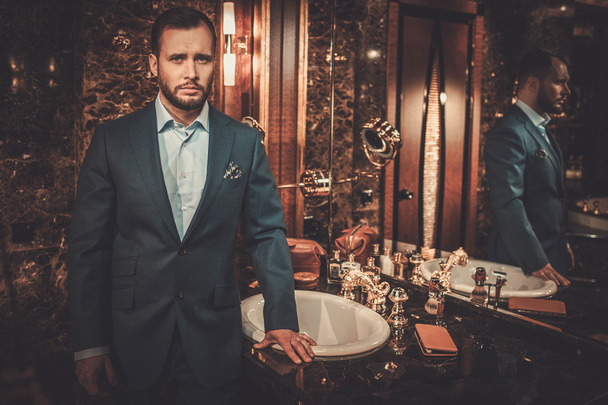 Homme confiant bien habillé dans l'intérieur de la salle de bain de luxe
. - Photo, image