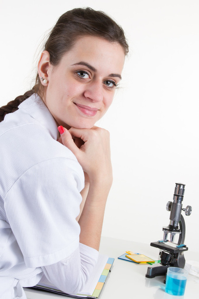 Female scientist looking through a microscope in laboratory - Фото, зображення