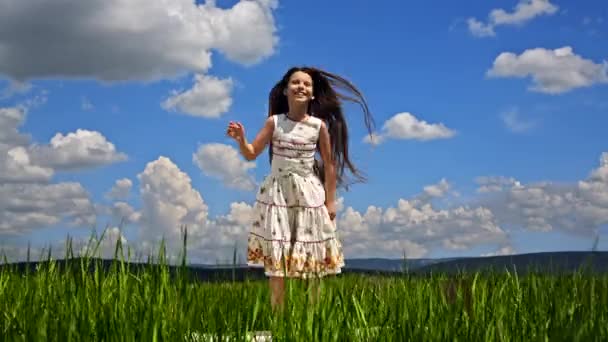 Kaunis tyttö hyppää vihreä kenttä
 - Materiaali, video