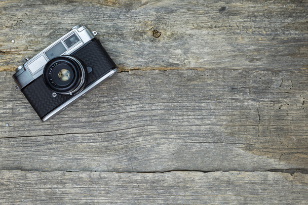 Старая аналоговая камера на деревянной поверхности
 - Фото, изображение