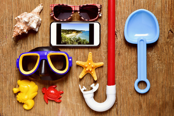smartphone e algumas coisas de verão em uma mesa de madeira rústica
 - Foto, Imagem