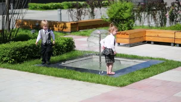 Little boy and girl near fountain - Imágenes, Vídeo