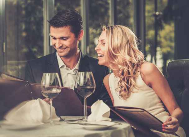 Casal alegre com menu em um restaurante
  - Foto, Imagem