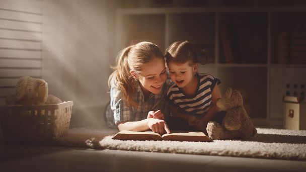 幸せ家族母と娘は、夜に本を読む - 写真・画像