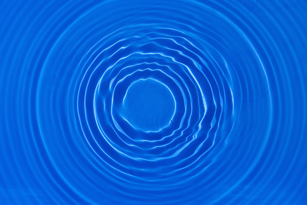 Splash kringen in blauw water  - Foto, afbeelding