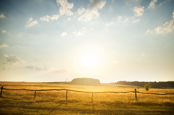 Puesta de sol sobre campo rural
 - Foto, Imagen