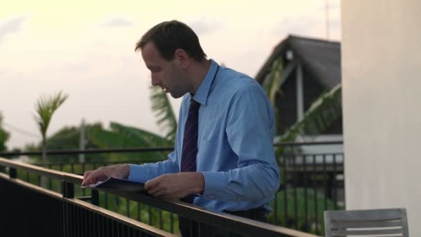 businessman reading documents on the terrace - Séquence, vidéo