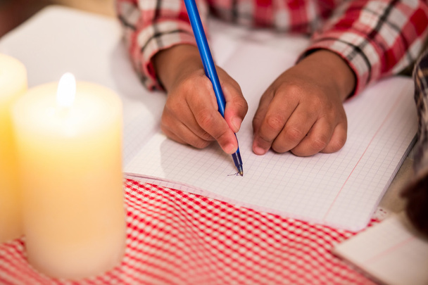 Bambino scrive lettera a lume di candela
. - Foto, immagini