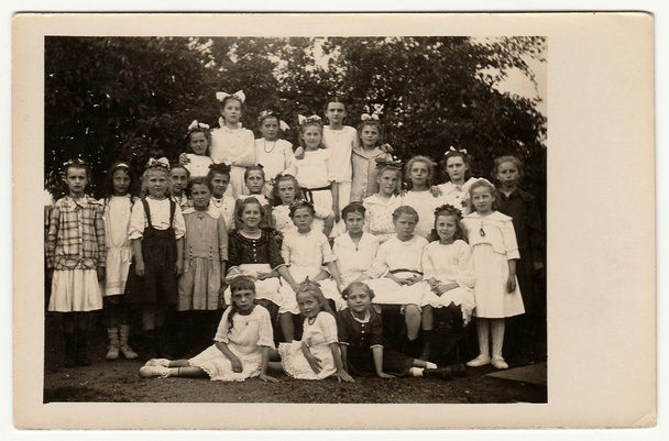 Vintage photo shows group of girls (schoolmates, pupils) pose outdoors. Black & white antique photography. - Photo, Image