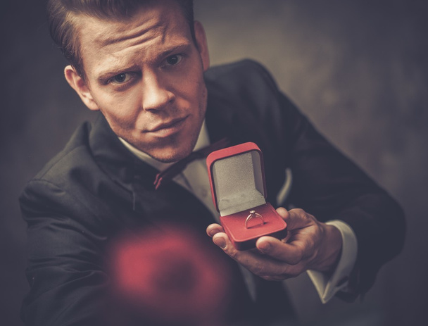 Άνθρωπος που κρατά το κουτί με μια πρόταση δαχτυλίδι και το κόκκινο τριαντάφυλλο - Φωτογραφία, εικόνα