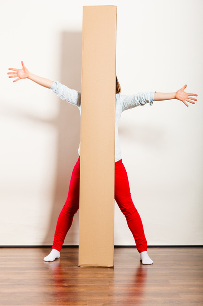 Happy woman moving into apartment carrying box. - 写真・画像
