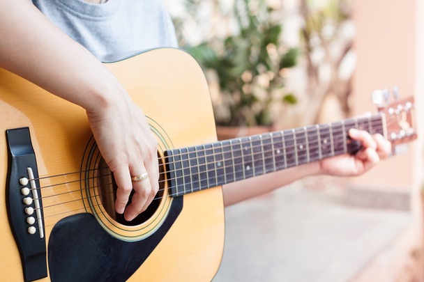 manos de mujer tocando la guitarra acústica
 - Foto, imagen